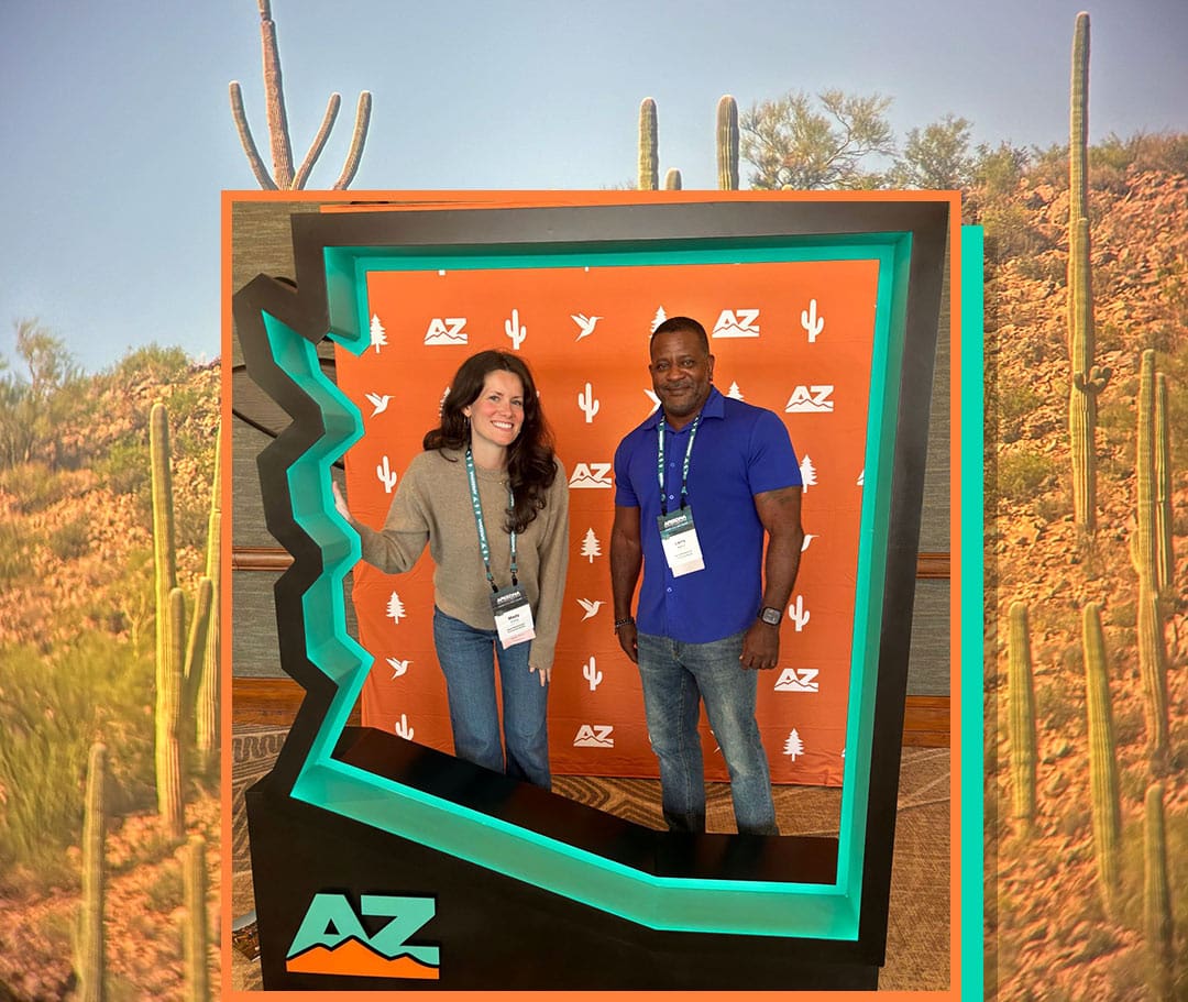 Mady and Larry inside an Arizona state shaped photo booth.