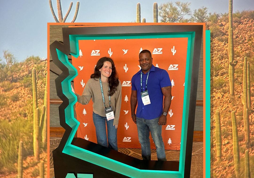 Mady and Larry inside an Arizona state shaped photo booth.