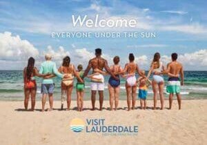 Visit Lauderdale - Everyone Under the Sun - Diverse set of people, back to camera, arms around eachother, on beach facing ocean.